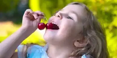 maedchen-ist-mit-freude-kirschen-im-ferienlager