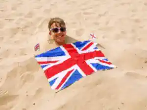 englischcamp-kroatien ein-sprachschueler-liegt-im-sand-mit-der-union-jack-flag