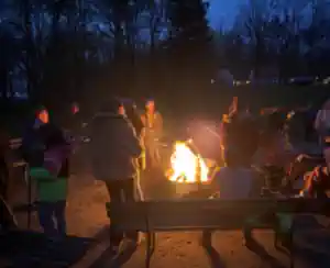 eine-gruppe-kinder-am-lagerfeuer-mit-angeboten-der-ferienfreizeit