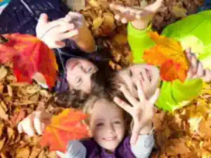 kinderferien-ohne-eltern auf-dem-kinderbauernhof-spielen-kinder-mit-dem-bunten-herbstlaub