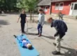 vier-jungen-bauen-eine-trage-bei-ihrer-klassenfahrt-mit-teambuilding
