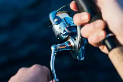 ein-jugendlicher-angler-holt-mit-der-rolle-einen-fisch