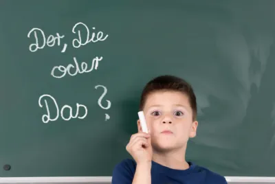sprachcamps-deutsch ein-junge-schreibt-an-der tafel-mit-kreide