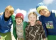 vier-jungen-freuen-sich-auf-das-feriencamp-mit-film-drehen