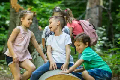 adhs-ferienlager unsere-kinder-sitzen-euf-einem-baumstamm-und-haben-spass