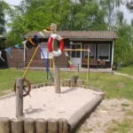 Ein Spielplatz mit einem großem Schiff und einem Buddelkasten darin.