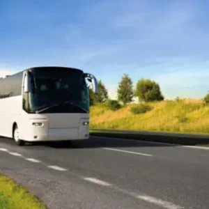 Ein weißer Bus - Transfer auf einer Bundesstraße auf dem Weg ins Ferienlager