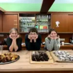 drei Kinder zeigen stolz ihre Kochkünste für das Mittagessen.