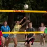 outdoor-sport die großen Reiseteilnehmer spielen Beachvolleyball