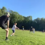 Die Kinder spielen cricket auf der Wiese am Rande der Saale.