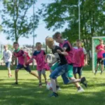 sportferienlager einige Jungs spielen auf dem Rasenplatz Fußball