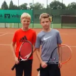 tenniscamp-jugend zwei Jugendliche stehen stolz auf dem Tennisplatz