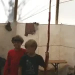 zwei Jungen schauen sich im Tipi die Gegenstände an