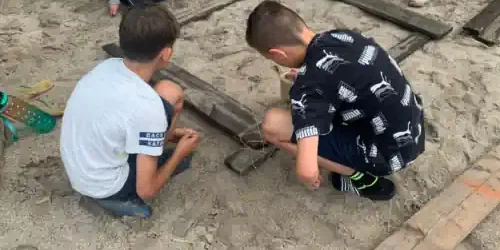 zwei Jungs bauen sich ein großes Spiel aus Holz