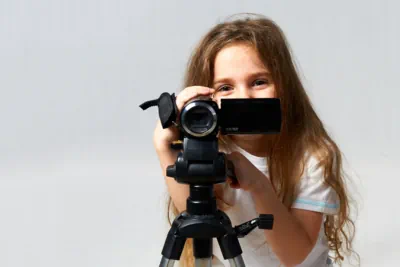 ein 8-jähriges Mädchen steht hinter der Kamera und filmt