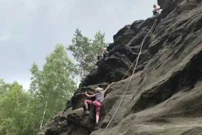 ein Mädchen klettert am Sandstein im Bielatal
