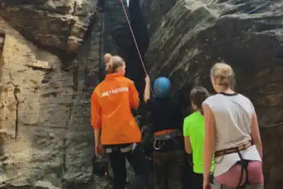 ein Betreuerin von ReiseMeise zeigt sichert beim Klettern