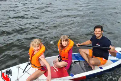 zwei Kinder und ein Betreuer auf dem SUP im günstigen Ferienlager